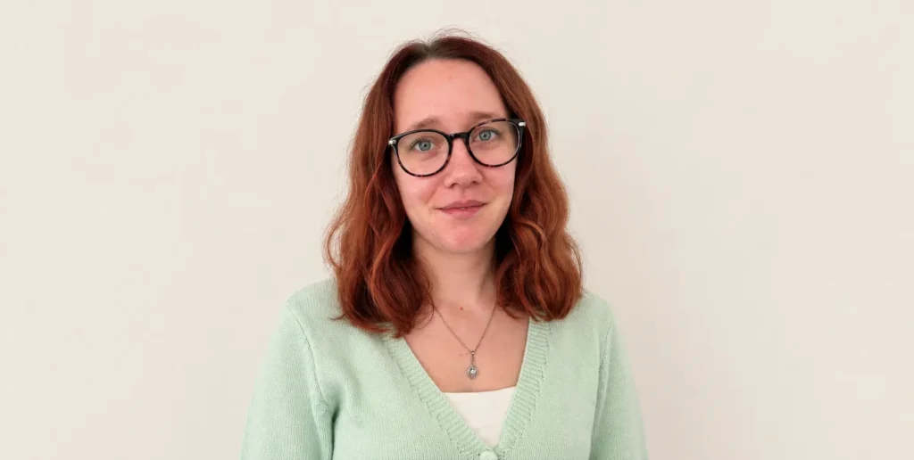 Photo of Abigail standing against beige backdrop