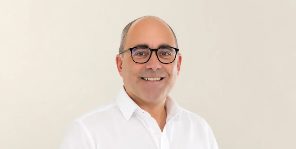 Photo of Vitale founder Dan Ayton, standing against beige backdrop