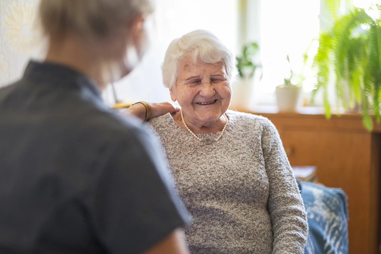 A female Care Professional supporting an older woman living with motor neurone disease