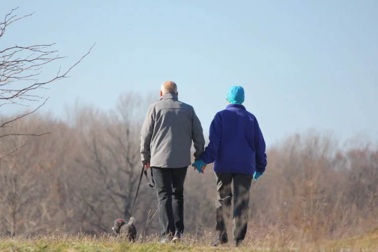 Senior couple walking together through a field on a cold day